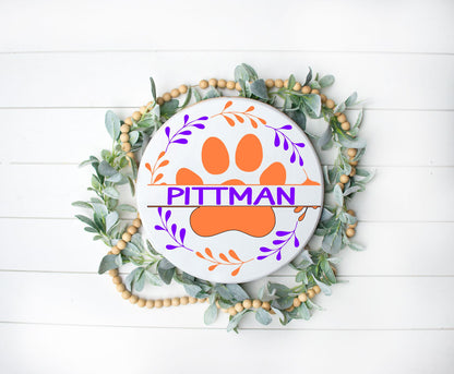 round or doorhanger with a paw print in the middle surrounded by a wreath with a last name